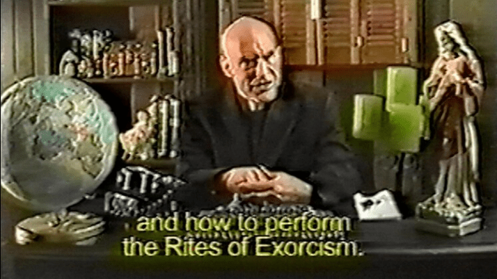 A still from What Happens Next Will Scare You. A grainy shot of a priest sitting behind a desk covered in religious tchotchkes has a caption that reads, "and how to perform the Rites of Exorcism."